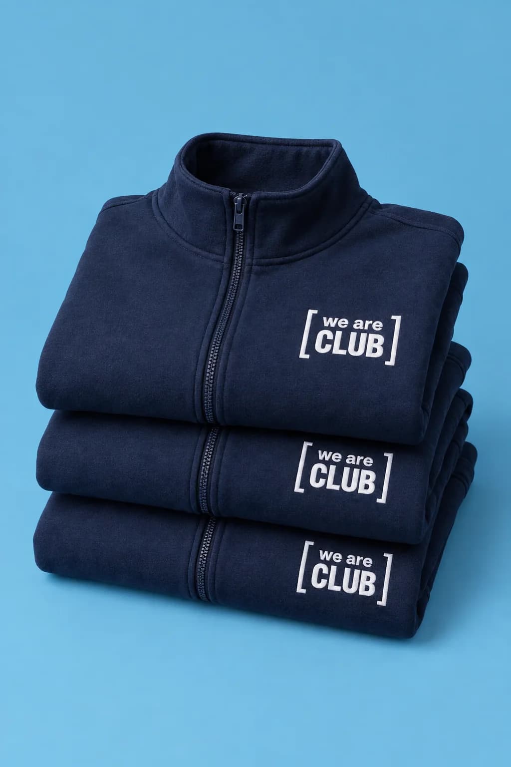 Pile de sweats zippés marine, brodés en blanc du cadre « we are club » sur la poitrine
