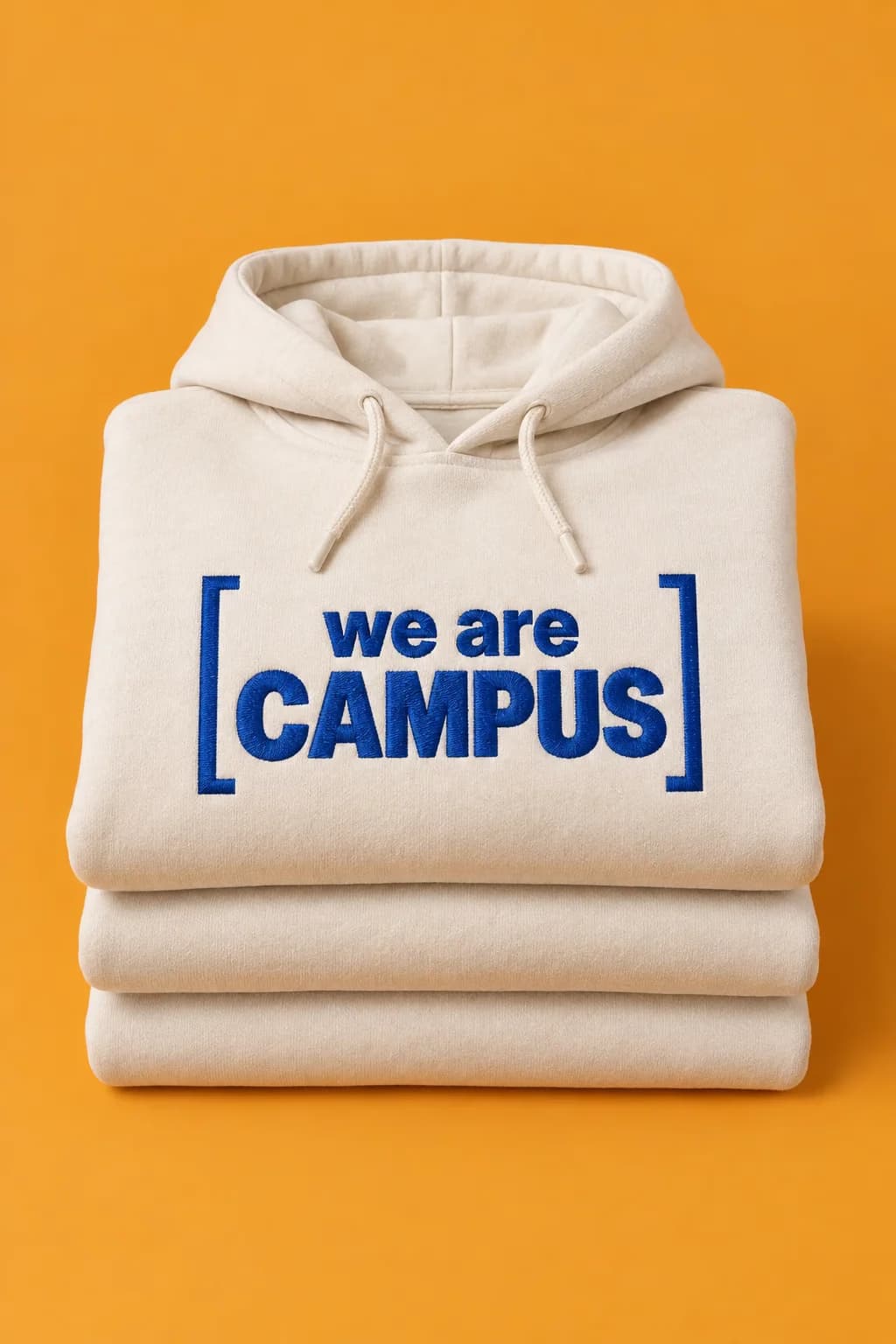 Pile de hoodies écru, brodés en bleu outremer du cadre « we are campus »