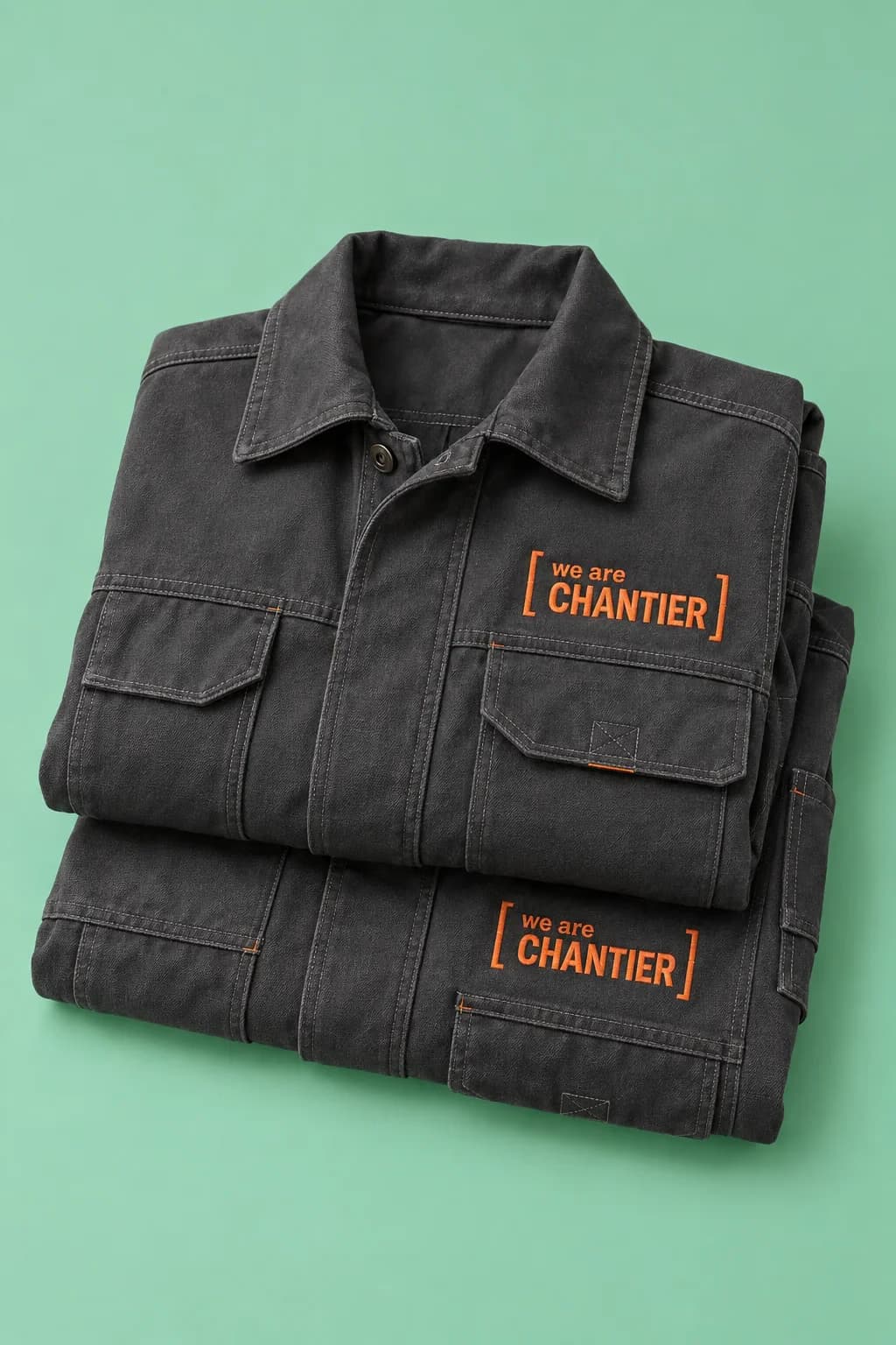 Vestes de travail en toile anthracite, brodées en orange du cadre « we are chantier »